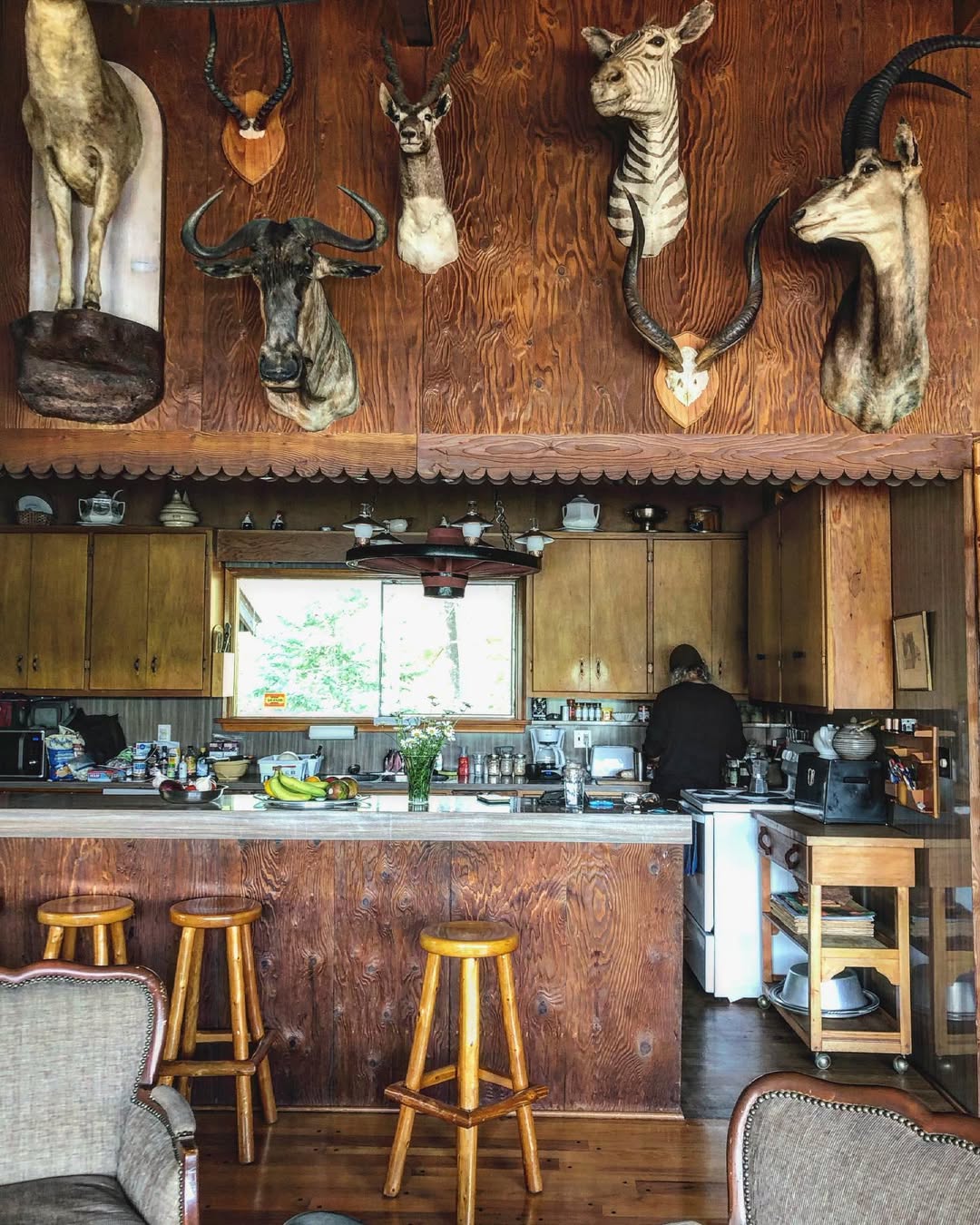 Rustic kitchen with bar seating and wood paneling in Main Lodge