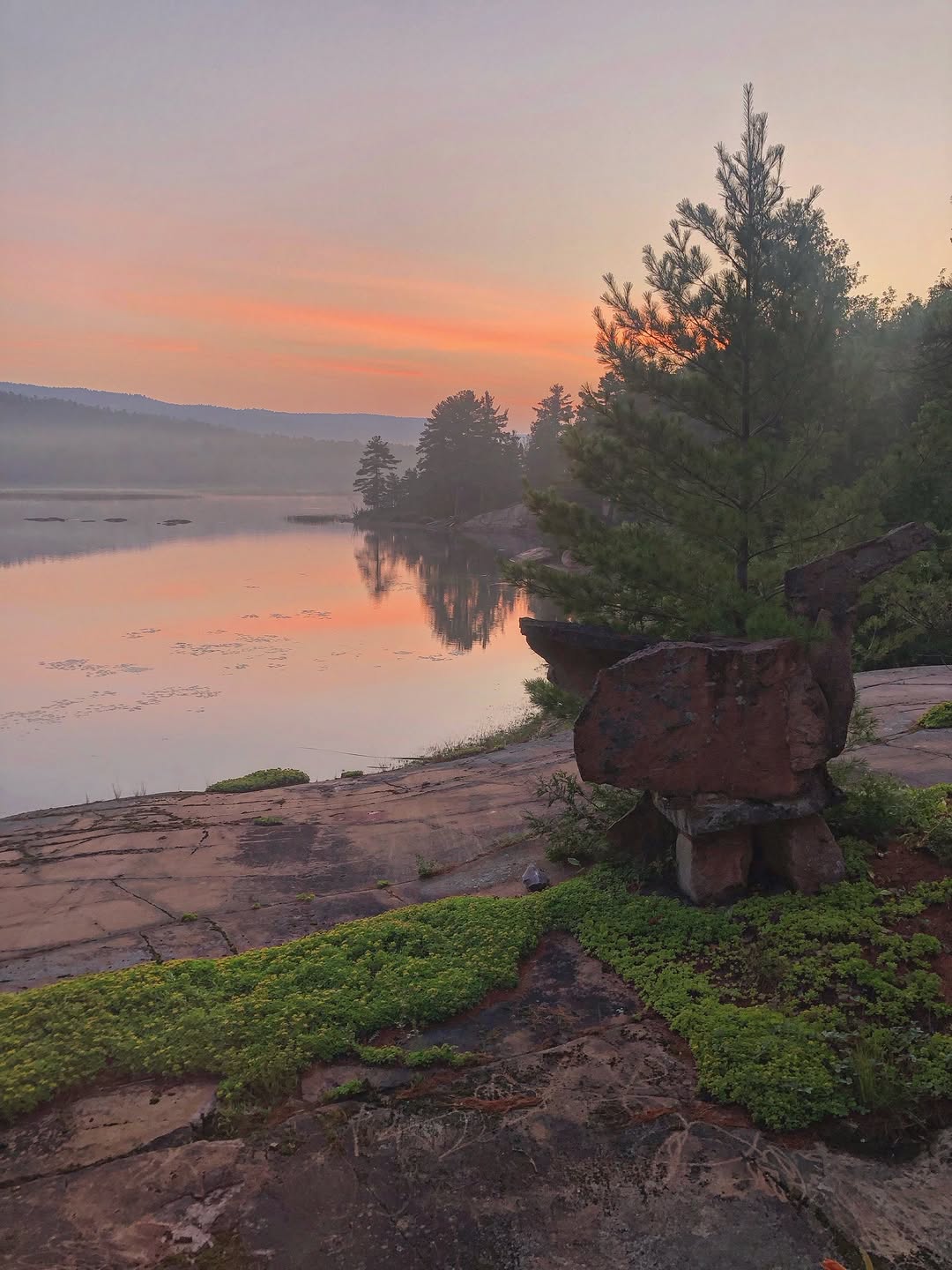 Pink granite shoreline at sunset overlooking Georgian Bay with quartzite mountains in the distance